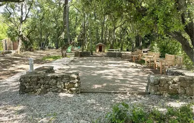 a stone path with tables and chairs under trees at Lovely Home In St Cannat in Saint-Cannat