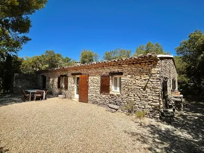 a stone house with a table in front of it at Maison paisible au coeur du Luberon in Bonnieux