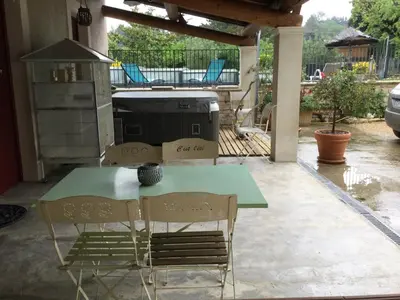 a green table and two chairs on a patio at 1 chambre 1 cuisine & salle d'eau privées avec piscine et jacuzzi in Eyragues