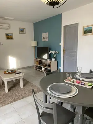 a living room with a table and chairs and a tv at Le gîte de Cambuisson in Velleron