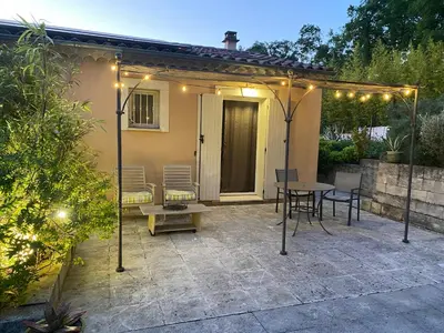 a patio with a table and chairs and lights at Le gîte de Cambuisson in Velleron