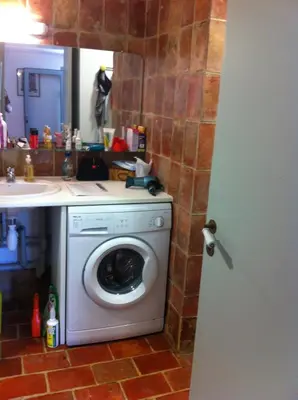 a bathroom with a washing machine and a sink at Maisonnette dans un parc du 18ème in Aix-en-Provence