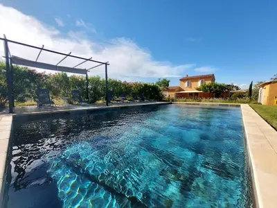 a swimming pool with blue water in a house at En Provence, Luberon, villa avec piscine à Maubec in Maubec