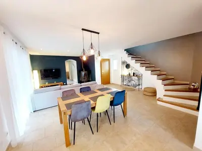a dining room with a table and chairs and a staircase at En Provence, Luberon, villa avec piscine à Maubec in Maubec