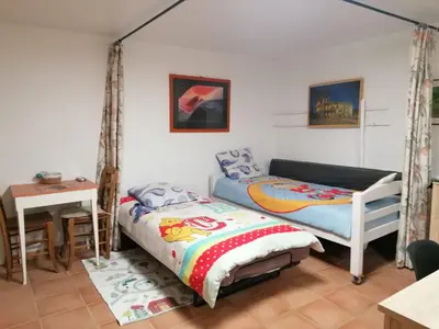 a bedroom with two beds and a table at Les chênes du lac in Saint-Saturnin-les-Apt