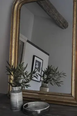 a mirror on a table with two potted plants at Brin d'Olivier en Luberon in Gargas
