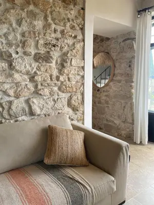 a living room with a couch and a stone wall at Brin d'Olivier en Luberon in Gargas