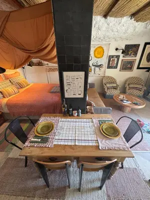 a room with a table and a bed at CaBaNa 52 La Suite troglodyte Proche Lourmarin in Cadenet