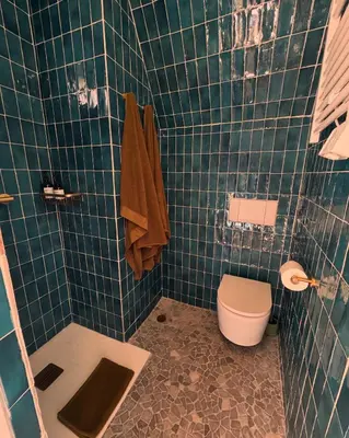 a bathroom with a toilet and a green tiled wall at CaBaNa 52 La Suite troglodyte Proche Lourmarin in Cadenet