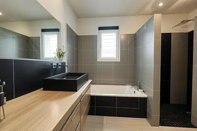 a bathroom with a black sink and a tub at Le temps de vivre in Mormoiron