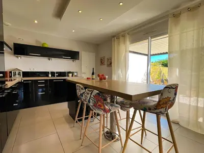 a kitchen with a wooden table and some chairs at Le temps de vivre in Mormoiron