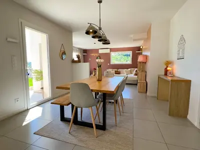 a kitchen and dining room with a wooden table and chairs at Le temps de vivre in Mormoiron