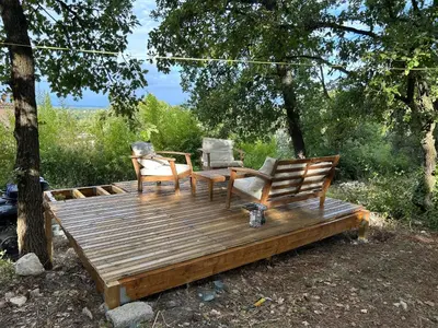 two chairs and a table on a wooden deck at Maison confortable à Velleron de 50 m² avec piscine in Velleron