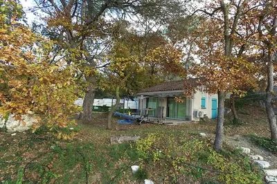 a small house in a yard with trees at Maison confortable à Velleron de 50 m² avec piscine in Velleron
