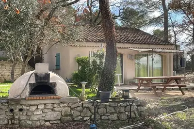 a stone oven in a yard with a picnic table at Maison confortable à Velleron de 50 m² avec piscine in Velleron