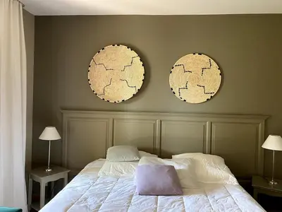a bedroom with two mirrors on the wall and a bed at Élégant appartement sur le Golf de Pont Royal in Mallemort