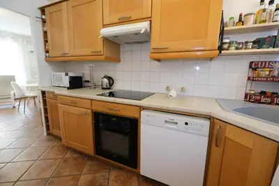 a kitchen with wooden cabinets and a white dishwasher at Three bedrooms apartment in Aix en Pce in Aix-en-Provence