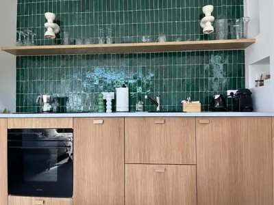 a kitchen with green tiled walls and a sink at La Réserve Hôtes in Aix-en-Provence