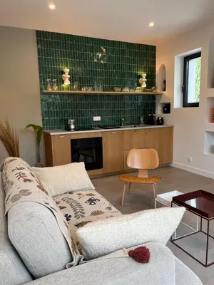 a living room with a couch and a green wall at La Réserve Hôtes in Aix-en-Provence