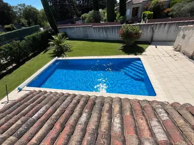 a swimming pool in a yard next to a house at Au Bon Mistral in Monteux