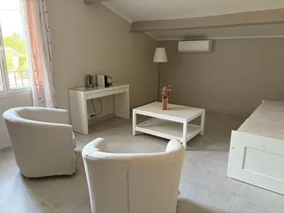 a living room with two chairs and a table at Au Bon Mistral in Monteux