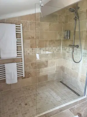 a bathroom with a shower with a glass door at Au Bon Mistral in Monteux