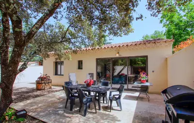 a patio with a table and chairs in front of a house at Charmant Mazet Provençal in Mazan