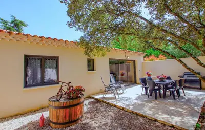 a patio of a house with a table and chairs at Charmant Mazet Provençal in Mazan