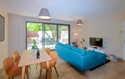 a living room with a blue couch and a table at Charmant Mazet Provençal in Mazan