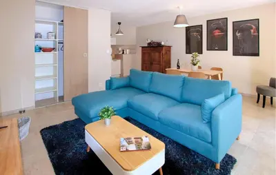 a living room with a blue couch and a table at Charmant Mazet Provençal in Mazan