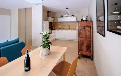a kitchen and dining room with a table and a bottle of wine at Charmant Mazet Provençal in Mazan