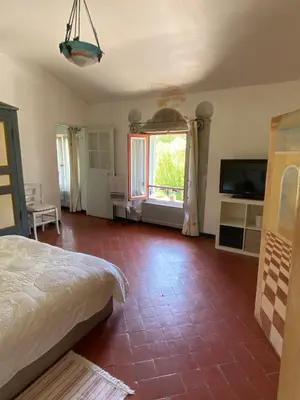 a bedroom with a bed and a television and a room at Syrius - Artist's apartment with terrace and view in Fontaine-de-Vaucluse