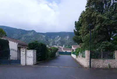 an empty street with a fence and a mountain at Catherine&Martial in Maubec