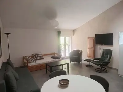 a living room with a bed and a table and chairs at GitesLuberon 3 in Charleval