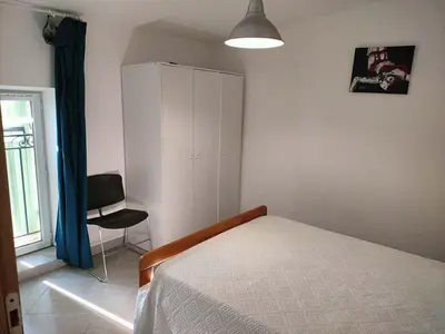 a bedroom with a bed and a chair and a cabinet at GitesLuberon 4 in Charleval