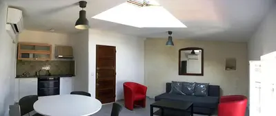 a living room with a white table and red chairs at GitesLuberon 4 in Charleval