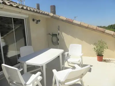 a group of white chairs and a table on a patio at GitesLuberon 5 in Charleval