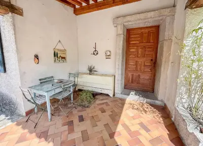 a patio with a table and a wooden door at Mon coeur de Provence in Banon