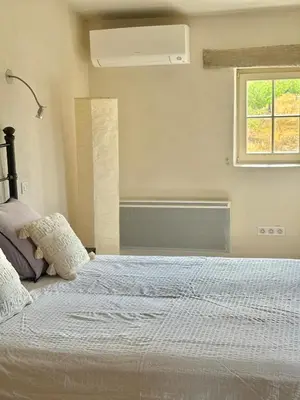 a bedroom with a white bed with a window at Bastidon Silvestre in Saint-Saturnin-les-Apt