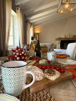 a table with a plate of tomatoes and a coffee cup at Le Mas de Cabrières in Cabrières-dʼAvignon