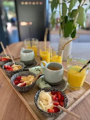 a table with bowls of fruit and cups of orange juice at Peaceful Family Retreat In Aix-En-Provence in Puyricard