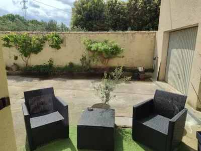 a patio with two chairs and a table with a plant at Chambre indépendante avec SDB privative in Avignon