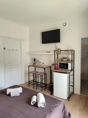 a room with a bed and a kitchen with a microwave at Chambre indépendante avec SDB privative in Avignon