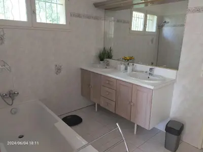 a bathroom with two sinks and a tub and a mirror at Studio Les Alizés du Luberon in Pertuis