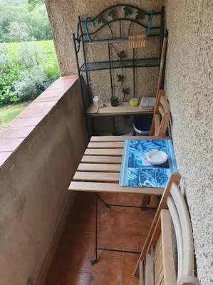 a bench sitting on a balcony with a table at Les Marronniers Charmant petit appartement a La Tour d'Aigues Vaucluse in La Tour-dʼAigues