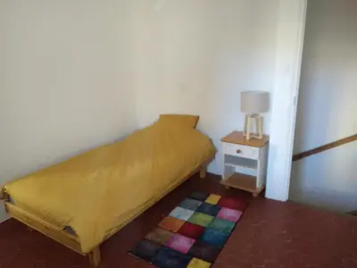 a small bedroom with a bed and a night stand at La Bastide des Jourdans logement entier Duplex in La Bastide-des-Jourdans