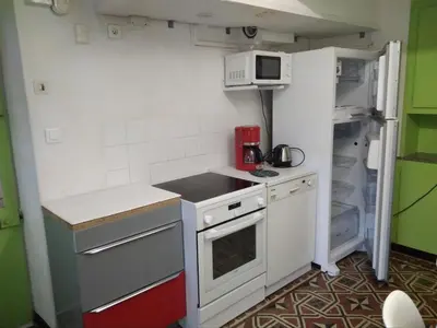 a small kitchen with a stove and a refrigerator at La Bastide des Jourdans logement entier Duplex in La Bastide-des-Jourdans
