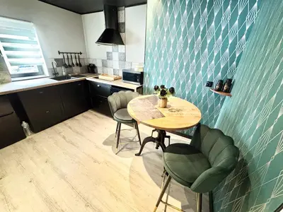 a kitchen with a table and chairs in a room at L'Or du Temps - Jacuzzi privé in Lançon-Provence