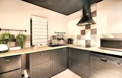 a kitchen with stainless steel cabinets and a microwave at L'Or du Temps - Jacuzzi privé in Lançon-Provence