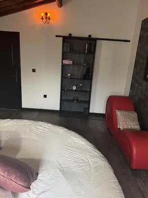 a bedroom with a bed and a red chair at L'Or du Temps - Jacuzzi privé in Lançon-Provence